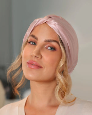Woman wearing a pink Lenoites Mulberry Silk Sleeping Cap, showing soft curls and a smooth, elegant look.