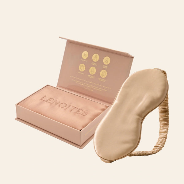 Pillowcase and Sleep Mask in Mulberry Silk by Lenoites featuring a beige silk sleep mask and a rosegold mulberry silk pillowcase presented in an open blush pink box against a soft light background.
