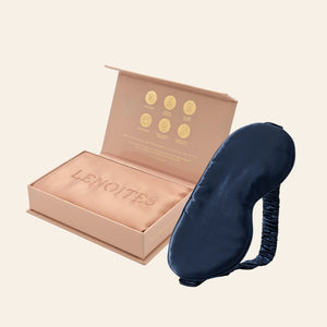Pillowcase and Sleep Mask in Mulberry Silk by Lenoites featuring a blue silk sleep mask and a rosegold mulberry silk pillowcase presented in an open blush pink box against a soft light background.
