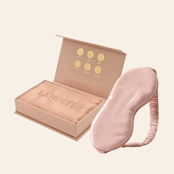 Pillowcase and Sleep Mask in Mulberry Silk by Lenoites featuring a pink silk sleep mask and a rosegold mulberry silk pillowcase presented in an open blush pink box against a soft light background.